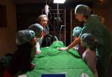 Els alumnes i la regidora Dolors Sardà assietixen a l'operació d'un peluix.
