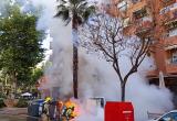 Bombers apagant la crema d'un contenidor a l'avinguda de Jaume I