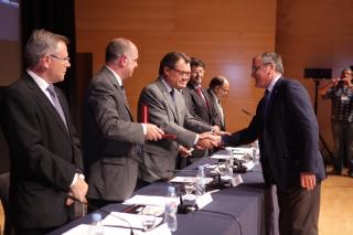 El president de la Generalitat i el rector de la Universitat Rovira i Virgili entreguen la medalla a l'alcalde de Reus.