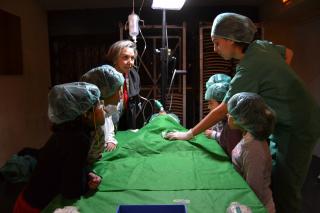 Els alumnes i la regidora Dolors Sardà assietixen a l'operació d'un peluix.