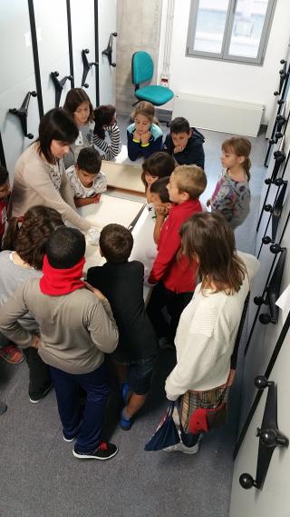 Els nens i nenes de l'escola La Vitxeta observant la documentació