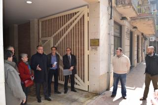 Imatge de la visita de l'alcalde i els veïns al portal del carrer Nou