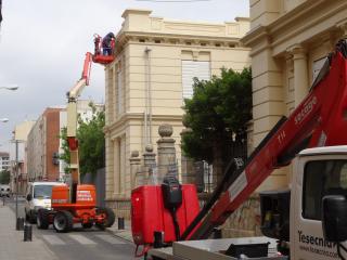 Imatge dels treballs d'instal·lació de la nova il·luminació ornamental a la façana de l'Escola Pompeu Fabra