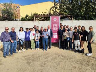 Foto de família amb la placa del parc infantil en memòria de Carles Macaya Prats.