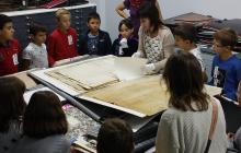 Els nens i nenes de l'escola La Vitxeta observant la documentació