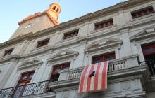 Foto de la senyera amb crespó negre a la façana de l'ajuntament